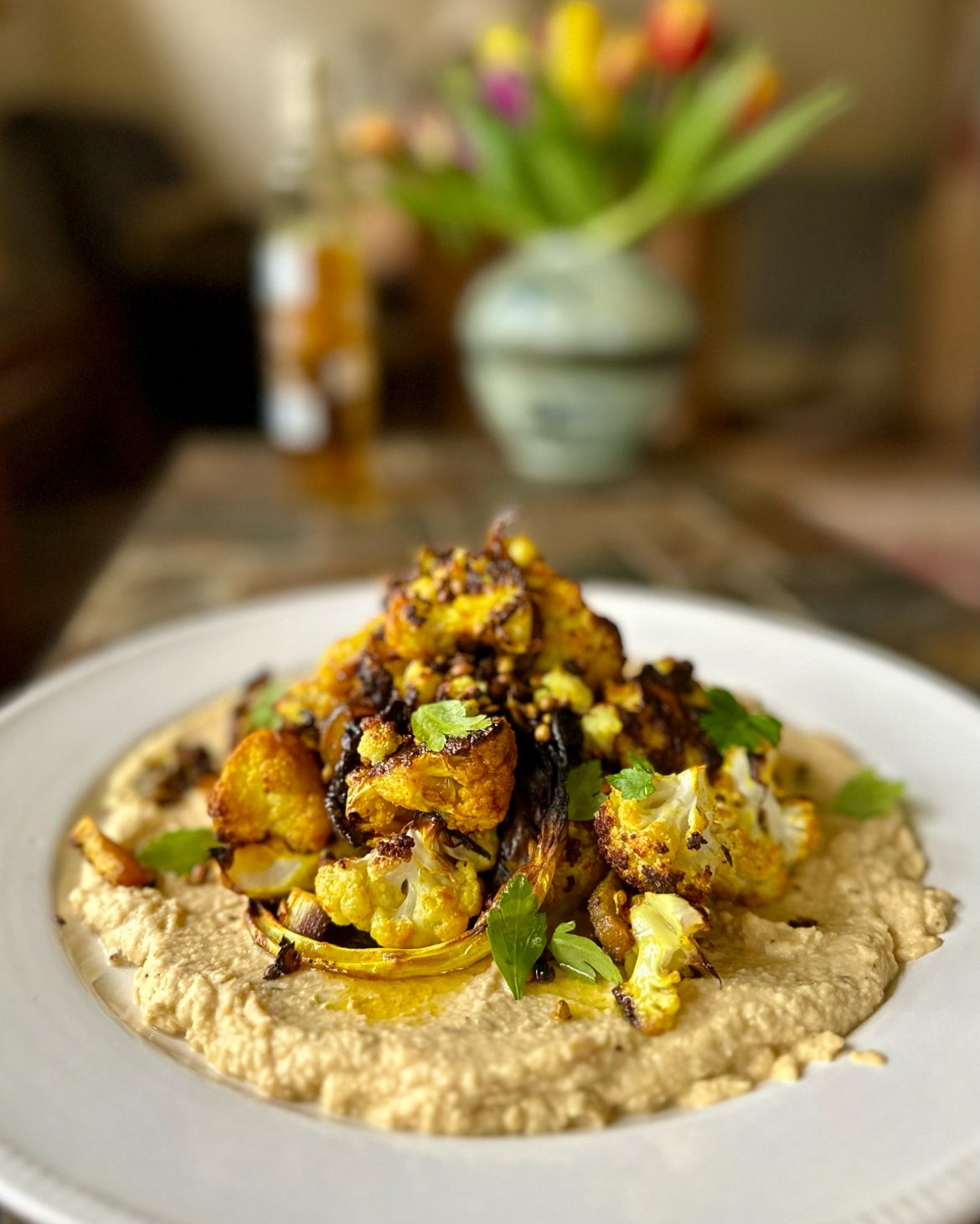 Spicy roast cauliflower and onion salad with hummus and golden oil
