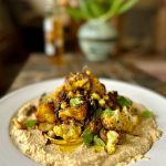 Spicy roast cauliflower and onion salad with hummus and golden oil